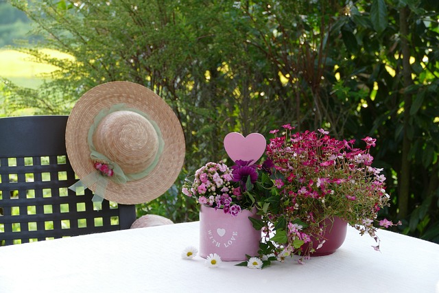 Photo of flowers sitting on a table and a hat hanging on a chair